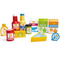 Colorful wooden toy food: milk and juice cartons, sauce bottles, jam, pesto, butter, yoghurt, and a cheese wedge.