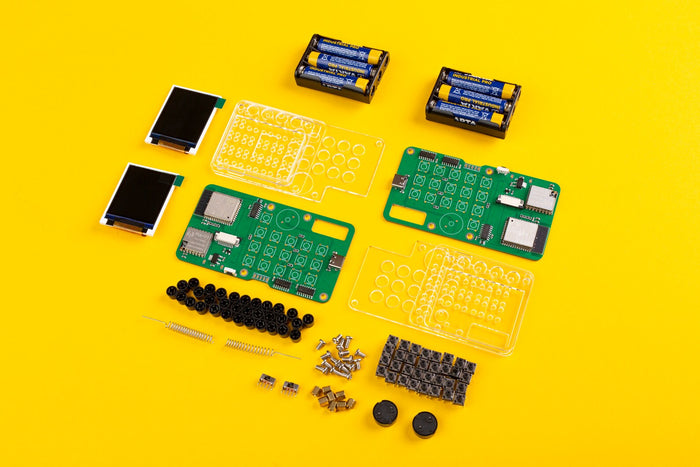 DIY walkie-talkie kit parts including green circuit boards, screens, and clear cases on a bright yellow background.