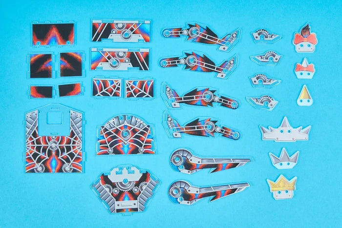 Flat acrylic toy components with steampunk gears and web designs on a solid blue background.