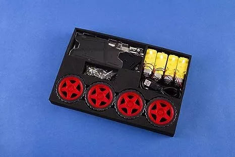 Black foam tray with four red wheels, yellow motors, black chassis parts, and screws on a blue background.