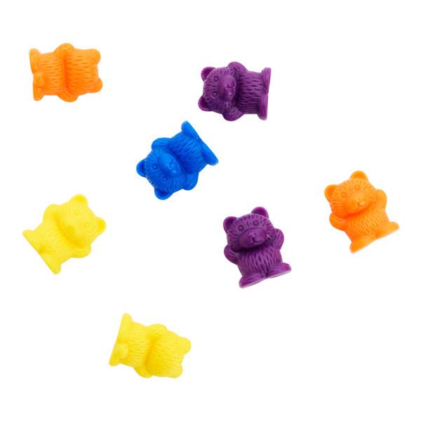 Seven small, textured plastic toy bears in yellow, orange, blue, and purple scattered on a white background.