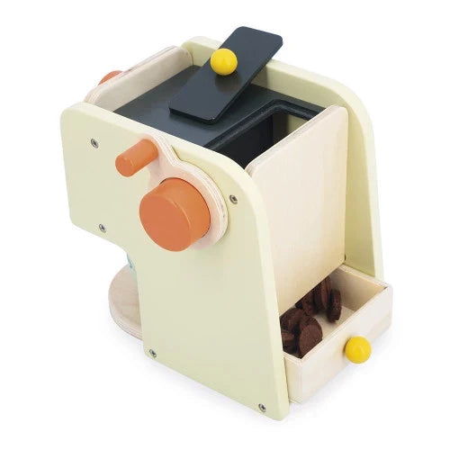 Pale green wooden toy coffee maker with orange knobs and a drawer containing dark brown wooden coffee bean discs.