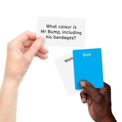 Hands hold a question card about Mr Bump's color and two answer cards, one blue and one white.