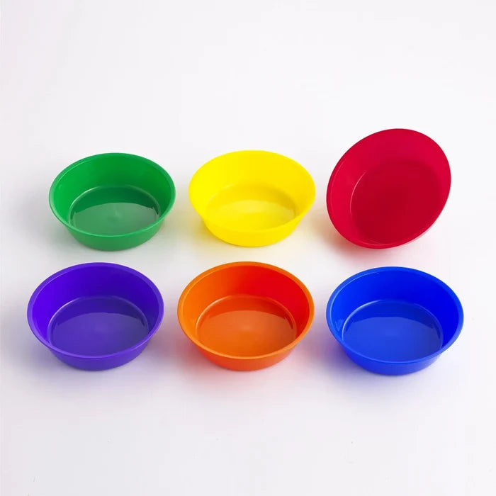 Six shallow round plastic bowls in green, yellow, red, purple, orange, and blue on a white background.