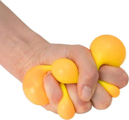 Hand squeezing a yellow squish ball that turns orange and bulges into rounded segments between the fingers.