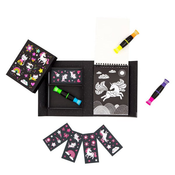 Black unicorn art kit featuring a spiral-bound sketchbook, stickers, and three dual-ended markers in neon colors.