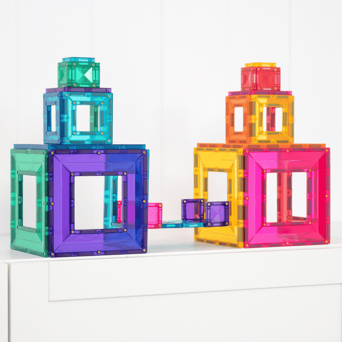 Two tiered towers and a bridge built with bright, translucent magnetic squares featuring open center cutouts.