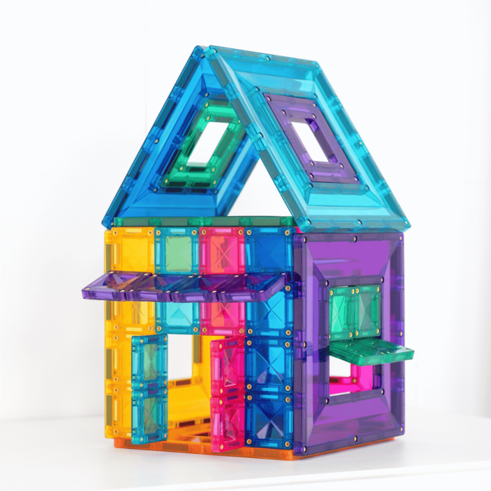 Toy house built with bright, translucent magnetic tiles featuring window portal frames in rainbow colors.