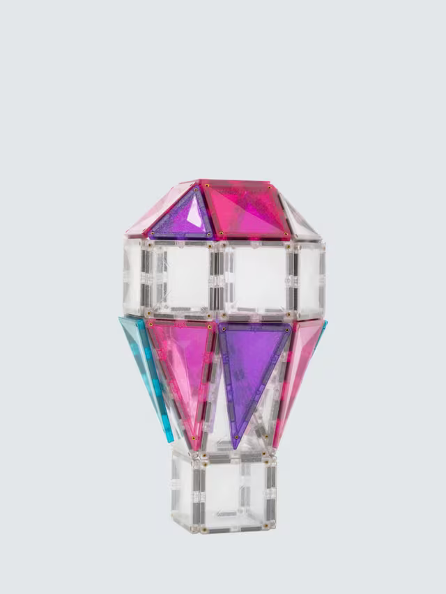 Hot air balloon model built with pink, purple, and blue glitter magnetic tiles and clear square pieces.
