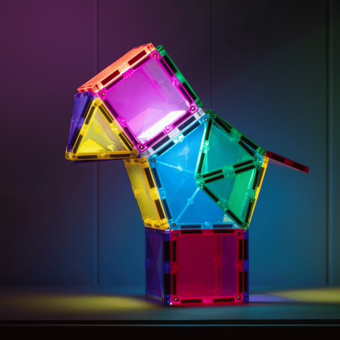 Vibrant animal figure built with glowing translucent magnetic square and triangle tiles in a dark setting.