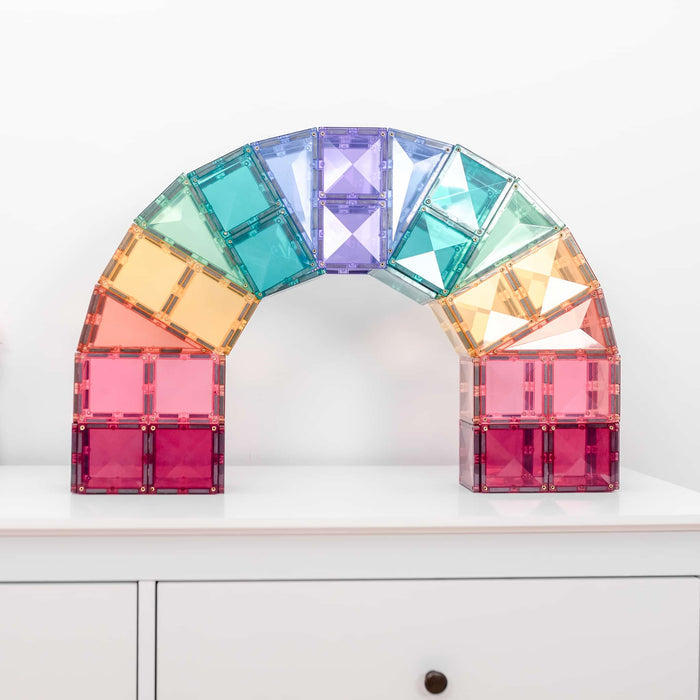 Translucent pastel square magnetic tiles built into a large rainbow arch on a white dresser.
