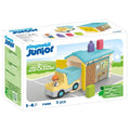 Playmobil Junior box showing a yellow construction truck, worker figure, and blue-roofed workshop shed with 9 pieces.