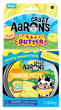 Yellow thinking putty in a tin. Bright blue and yellow packaging features a cartoon cow, toast, and yellow putty swirls.