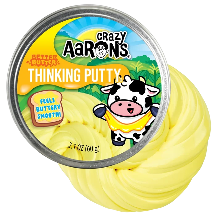 Pale yellow swirled thinking putty in a round metal tin with a cartoon cow and cornfields on a farm-themed label.
