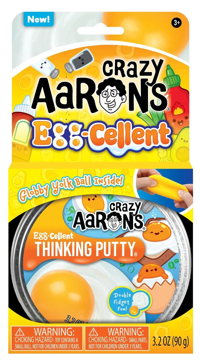 Yellow toy packaging for egg-themed putty with cartoon egg art and a round tin featuring a realistic fried egg graphic.