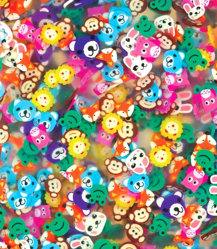 Close-up of clear putty filled with small, colorful animal-shaped charms like monkeys, frogs, foxes, and bears.
