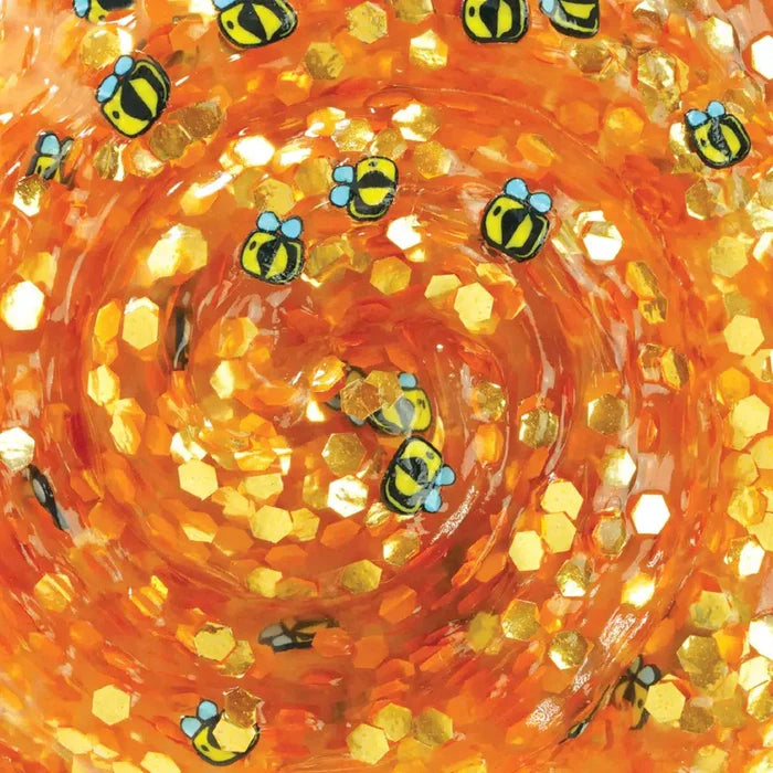 Swirled orange translucent putty filled with gold hexagonal glitter and small bee charms with blue wings.