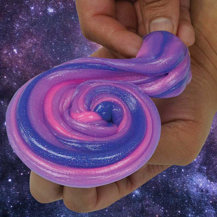 Hand holding a spiral of glittery purple, pink, and blue swirled putty against a starry space background.