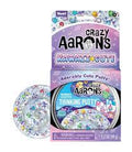 Purple Kawaii Cute Thinking Putty box beside clear putty containing colorful, miniature character-shaped charms.