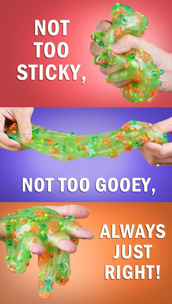 Green translucent slime with orange and green beads and dino charms being squeezed, stretched, and dripped.