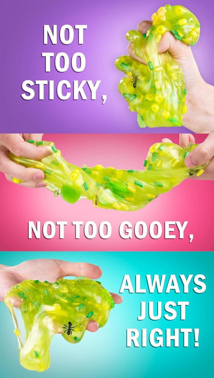 Hands squeeze and stretch translucent green slime filled with yellow and green bits and a plastic fly charm.