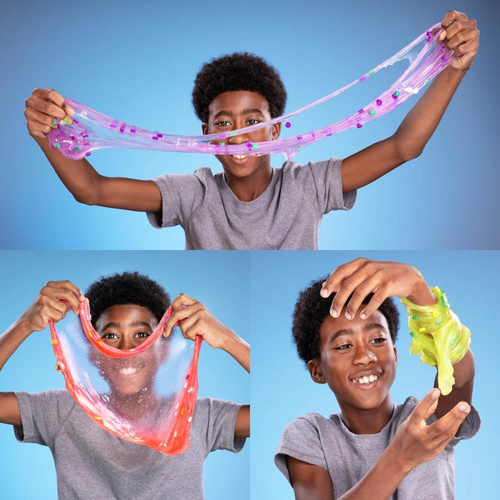 Boy stretching translucent purple, red, and neon green slime filled with colorful beads and small charms.