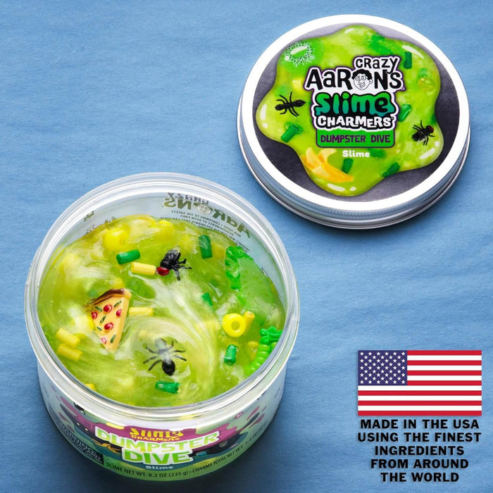 Jar of neon green slime with pizza and fly charms, next to its lid and a USA flag on a blue background.