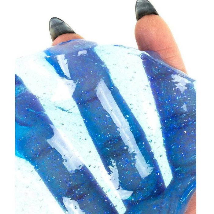 Translucent blue putty with fine shimmer and bubbles stretched across a hand with dark, pointed nails.
