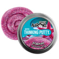 Sparkly pink glitter putty swirled behind a silver mini tin with a pink starfish design on the lid.