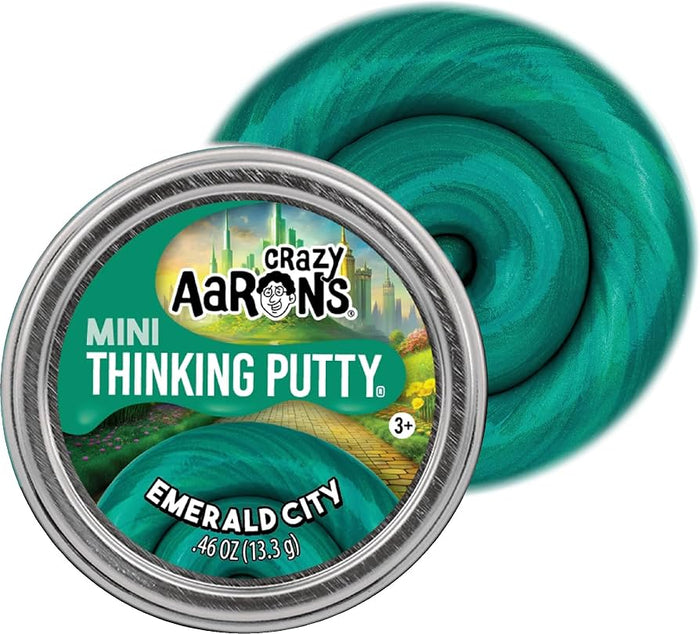 Round silver tin with a green cityscape label next to a swirl of shimmering teal green thinking putty.