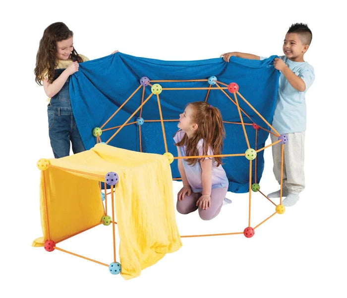 Children building forts using orange rods and colorful connector balls, draped with blue and yellow fabric.