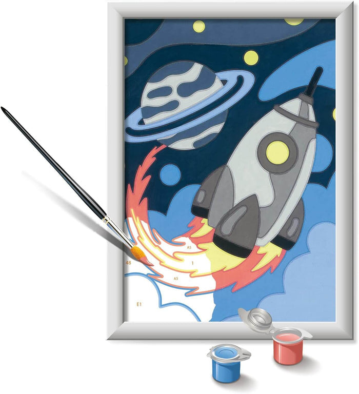 Framed space painting of a rocket and ringed planet with number codes, a paintbrush, and blue and red paint pots.