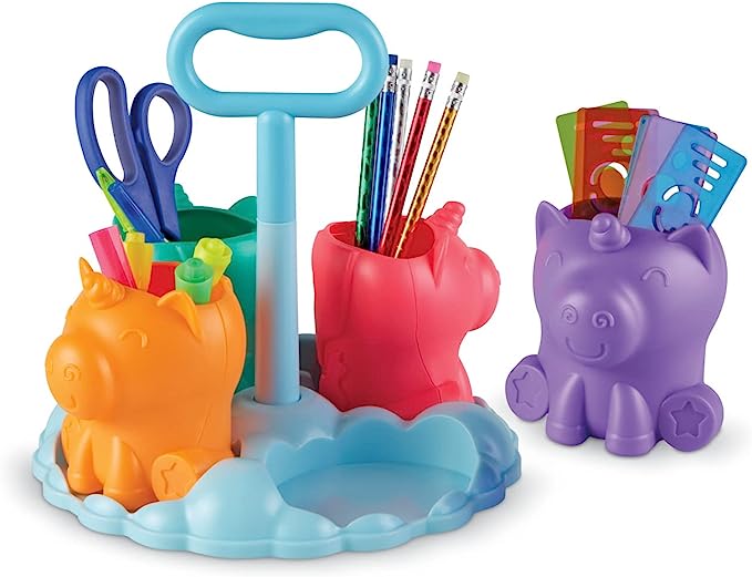 Colorful unicorn-shaped pen holders on a blue cloud base with a handle, filled with various school supplies.