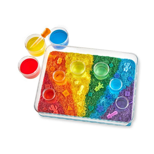 Clear tray with rainbow sand, colorful cups, and toy shapes. Includes extra cups of liquid and a dropper tool.