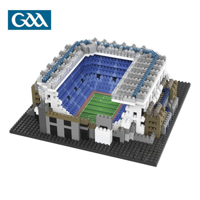 Micro-building block stadium model featuring blue seating, a green pitch, and grey walls on a black baseplate.