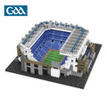 Micro-building block stadium model featuring blue seating, a green pitch, and grey walls on a black baseplate.