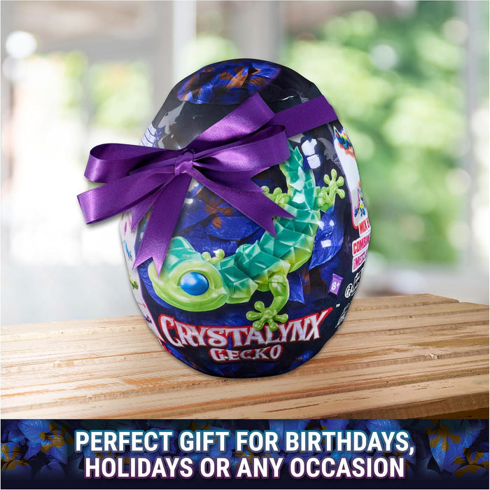 Egg-shaped package with a purple ribbon and green gecko illustration, sitting on a wooden surface.