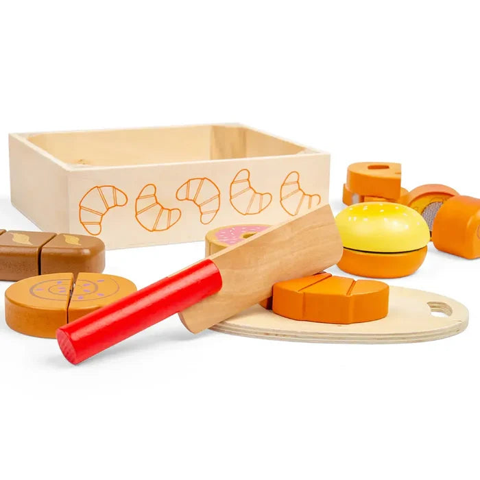 Wooden toy food set featuring a burger, donut, and bread with a red-handled knife, cutting board, and wooden crate.