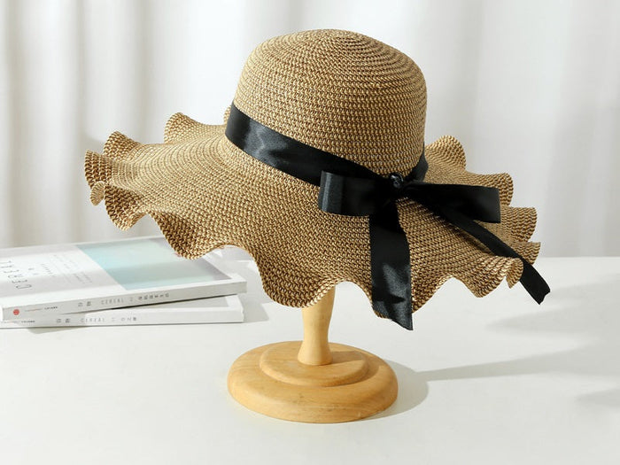 Women’s dark brown straw sun hat with wide brim, floppy derby style, perfect for summer beach outings and outdoor protection.