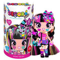 Fashion doll with pink and black pigtails, skull and heart stickers, next to a colorful cylindrical package.