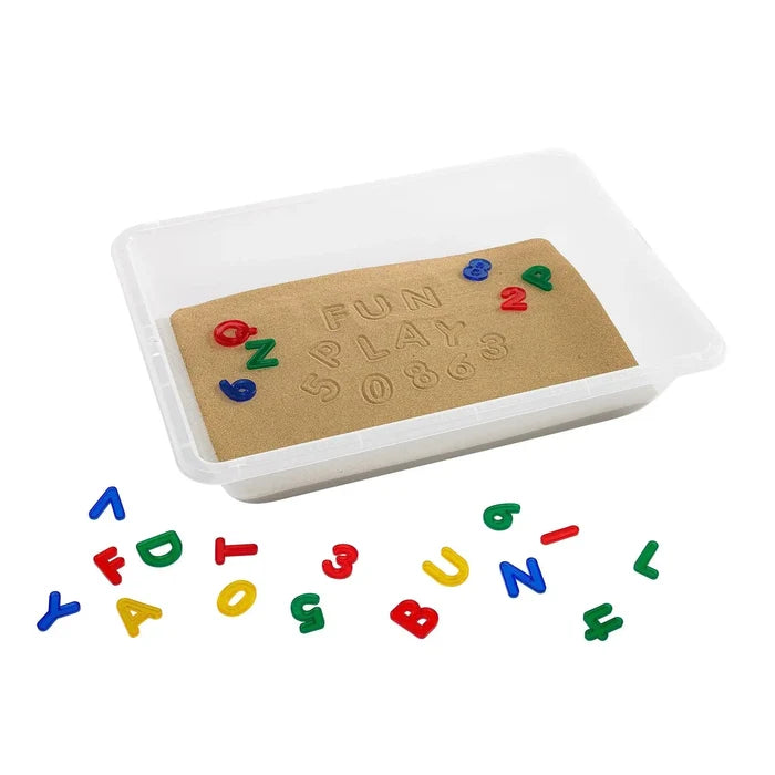 Rectangular translucent plastic tray filled with sand, stamped words, and colorful plastic letters and numbers.