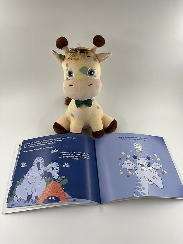 Spotted giraffe plush with a green bow tie sitting behind an open children's book with blue giraffe illustrations.