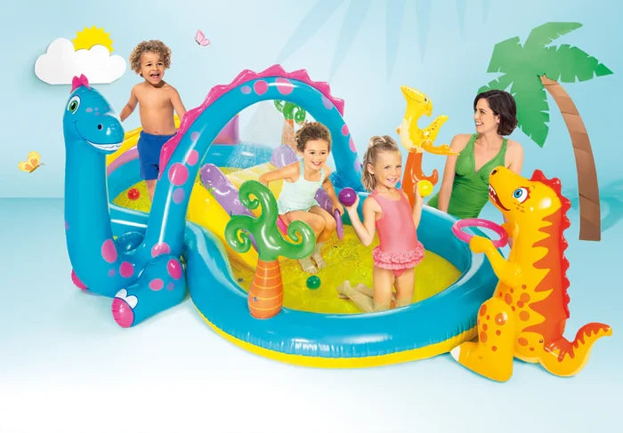 Inflatable blue and yellow dinosaur pool featuring a slide, arch sprayer, and children playing with toys and balls.