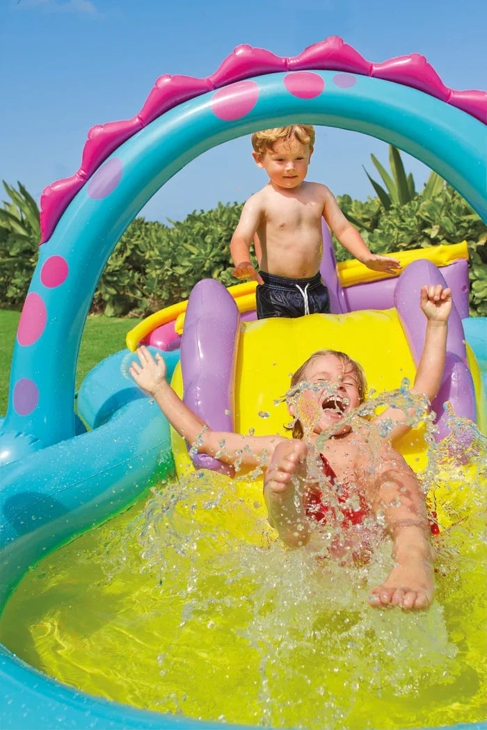 Children play in a blue and yellow inflatable pool with a dinosaur spray arch, slide, and purple spots.