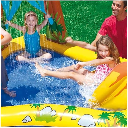Children splashing in a yellow jungle-themed inflatable pool with a slide and palm tree water sprayers.