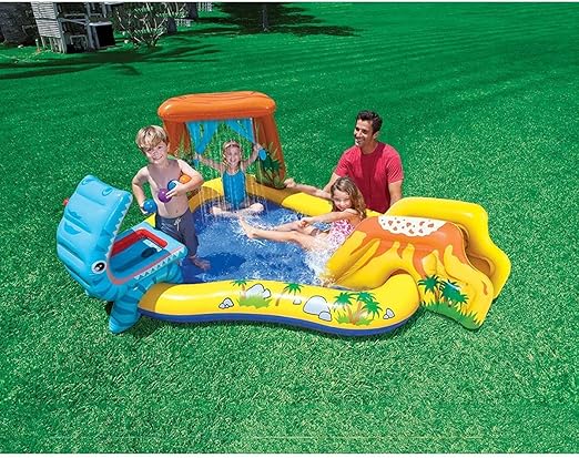 Inflatable dinosaur pool with a yellow volcano slide, blue splash area, and orange arch, shown with family on grass.