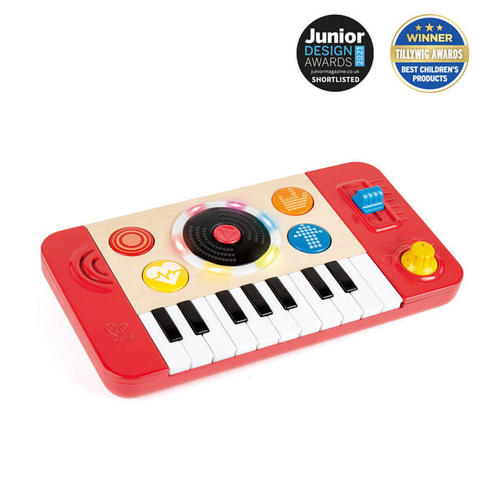 Wooden toy DJ deck with a red frame, mini piano keyboard, spinning light-up disc, and colorful control buttons.