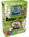 Lime green Dobble Junior game box featuring circular cards with colorful fantasy and food-themed cartoon graphics.
