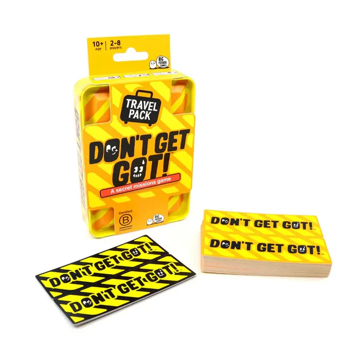 Yellow travel tin with orange hazard stripes and a briefcase logo, shown with a stack of matching mission cards.