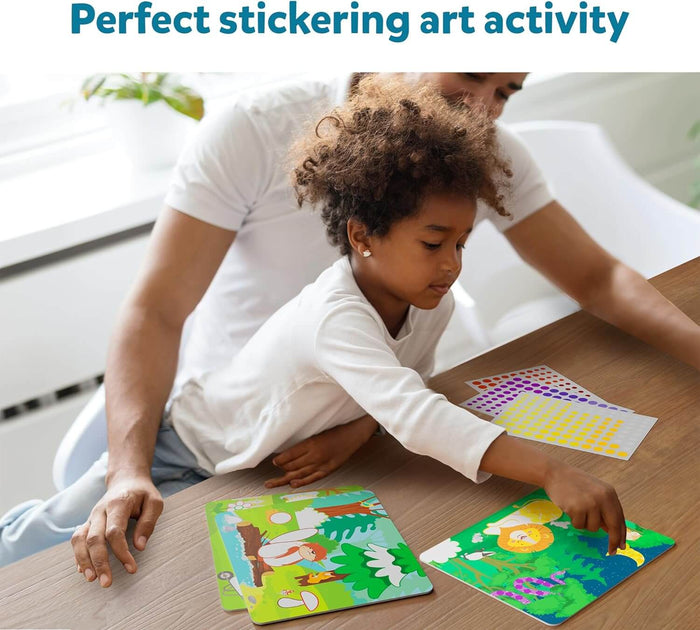 A child applies colorful round stickers to animal-themed art cards with an adult at a wooden table.
